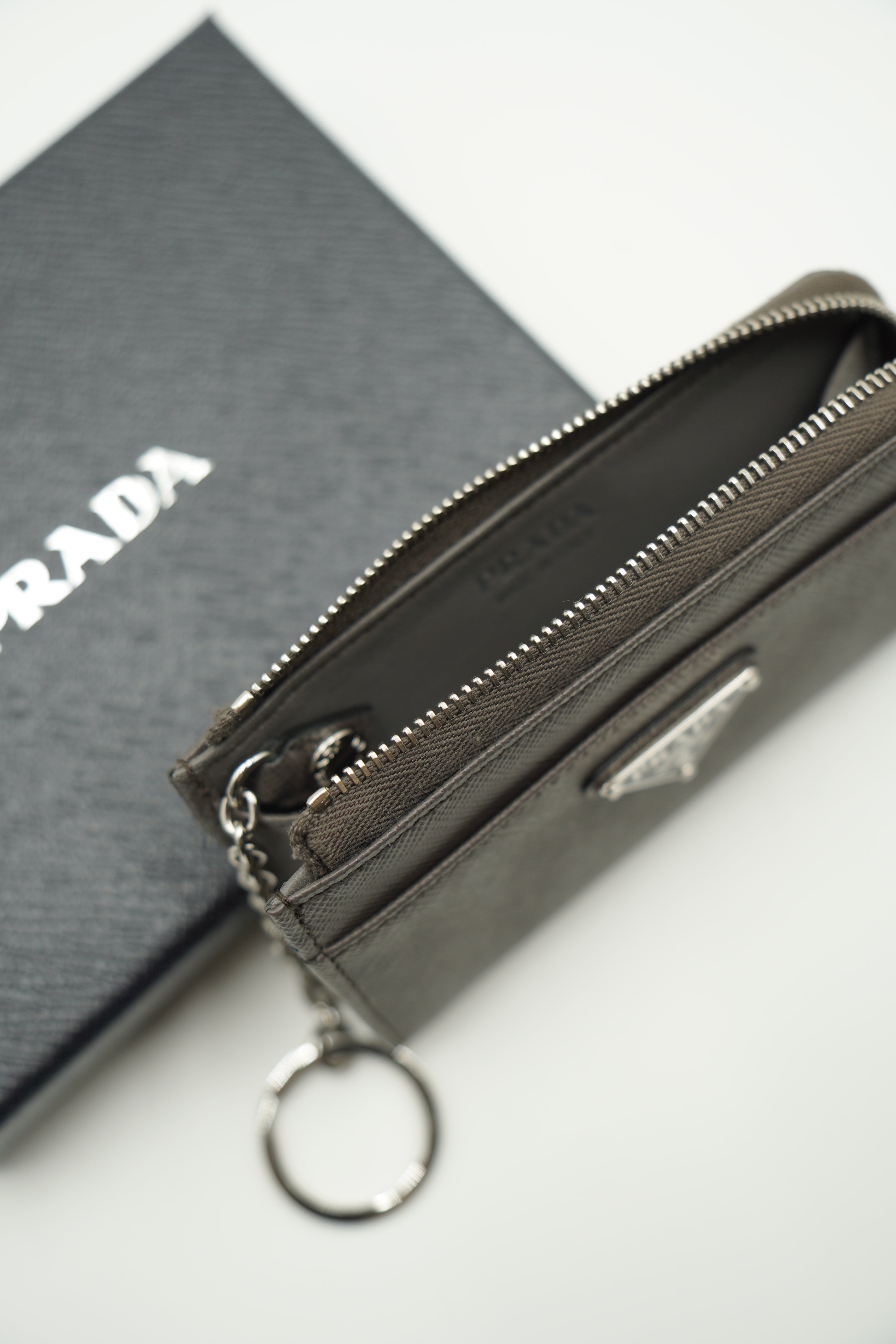 Cartera Prada con llavero en piel saffiano gris